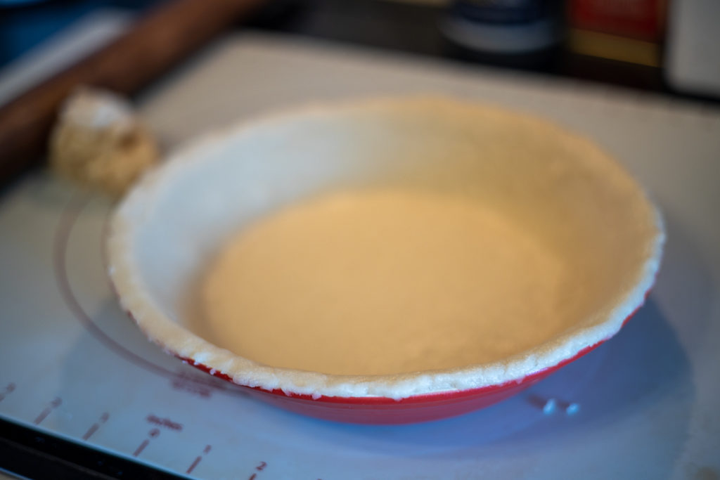 an uncooked pie crust in a pie plate
