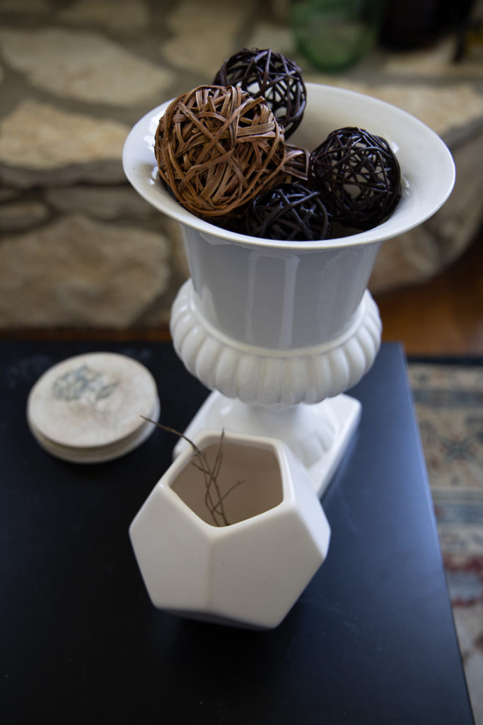 a white ceramic urn with balls made of wrapped wooden sticks