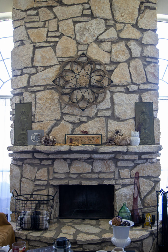 a fireplace mantle decorated with neutral fall decor